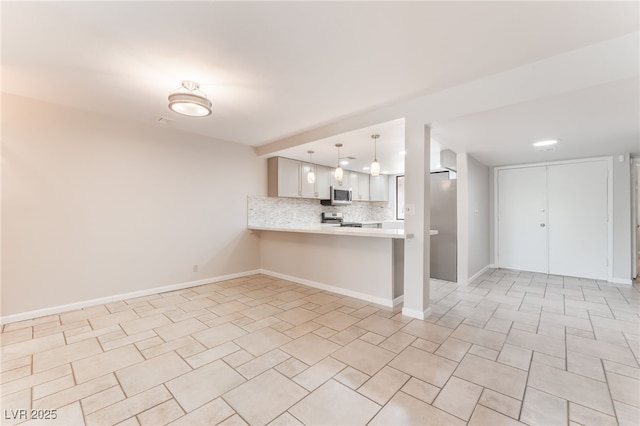 2486 Sabado St, Las Vegas, NV 89121 - kitchen with stainless steel appliances, light countertops, tasteful backsplash, open floor plan, and a peninsula
