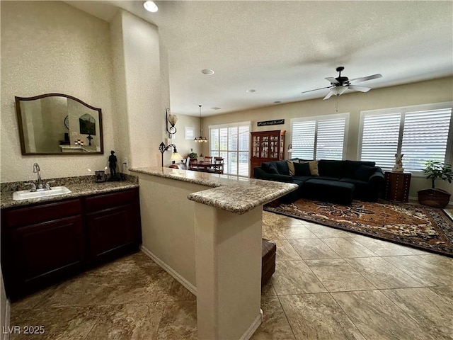 2257 Turner Falls St, Henderson, NV 89044 - kitchen with ceiling fan, a peninsula, and stone countertops