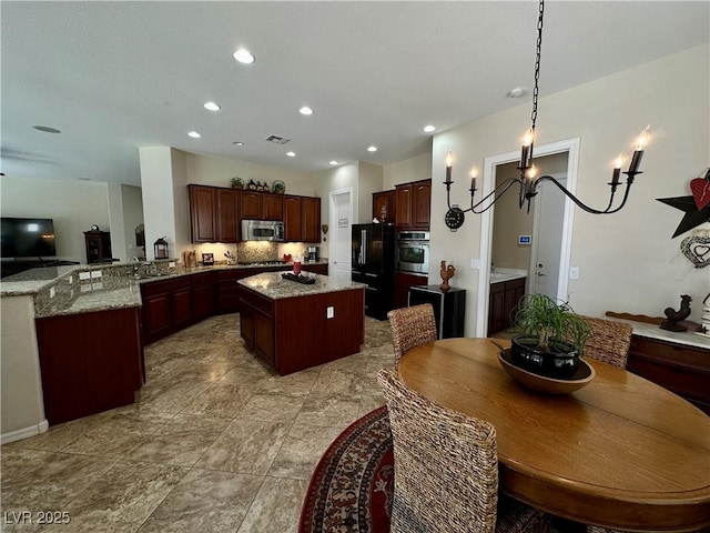 2257 Turner Falls St, Henderson, NV 89044 - kitchen with stainless steel appliances, a kitchen island, recessed lighting, a peninsula, and light stone counters