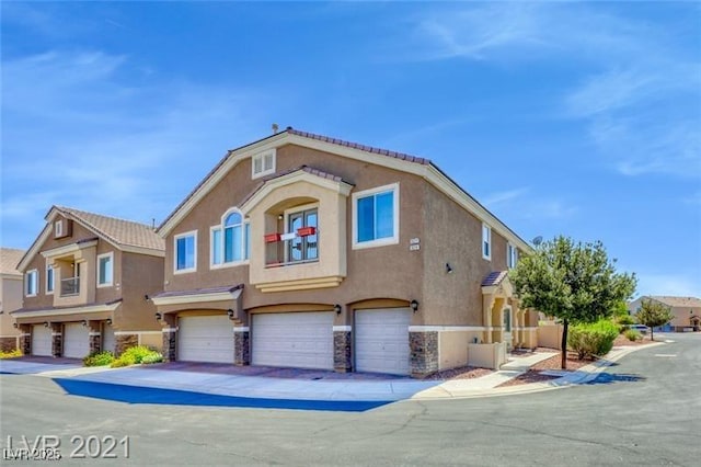 3521 Hazelnut Pine Pl Unit 1, North Las Vegas, NV 89084 - view of front of house with stucco siding, a garage, and stone siding