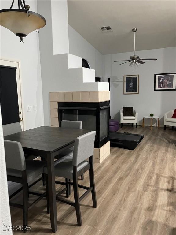 3521 Hazelnut Pine Pl Unit 1, North Las Vegas, NV 89084 - dining space with a tile fireplace, light wood finished floors, and ceiling fan