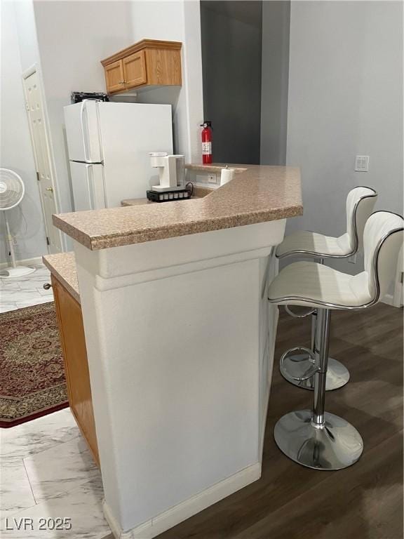 3521 Hazelnut Pine Pl Unit 1, North Las Vegas, NV 89084 - kitchen featuring freestanding refrigerator, light countertops, a peninsula, and brown cabinets