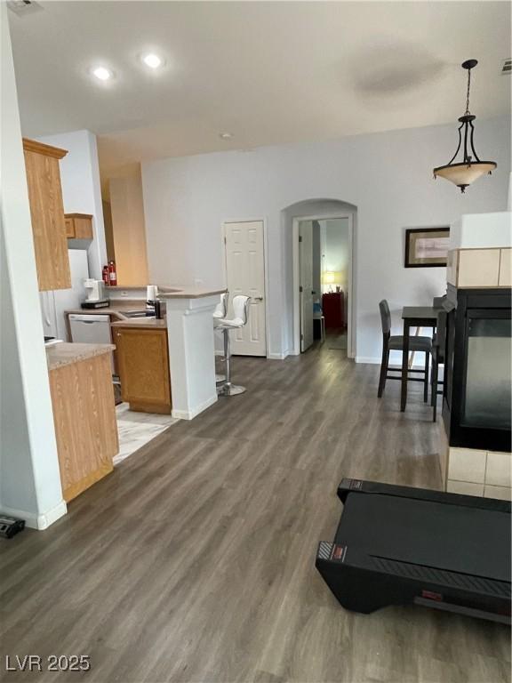 3521 Hazelnut Pine Pl Unit 1, North Las Vegas, NV 89084 - kitchen with arched walkways, wood finished floors, a peninsula, light countertops, and brown cabinetry