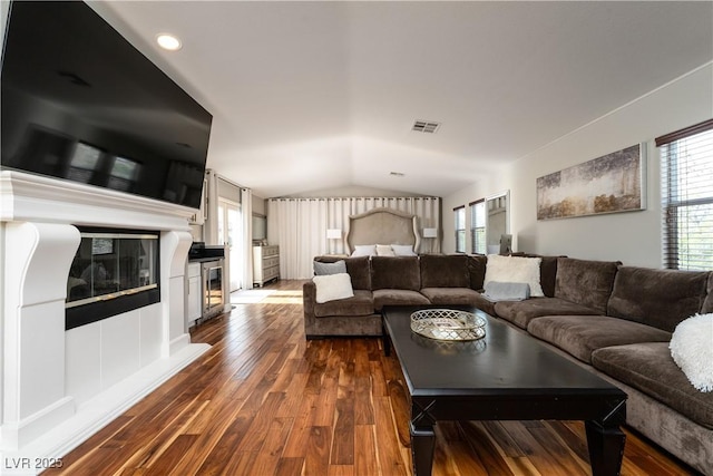 11830 Kingsbarns Ct, Las Vegas, NV 89141 - living room featuring dark wood-style floors, vaulted ceiling, and a glass covered fireplace