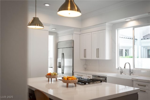 11830 Kingsbarns Ct, Las Vegas, NV 89141 - kitchen with stainless steel appliances, white cabinetry, light countertops, pendant lighting, and ornamental molding