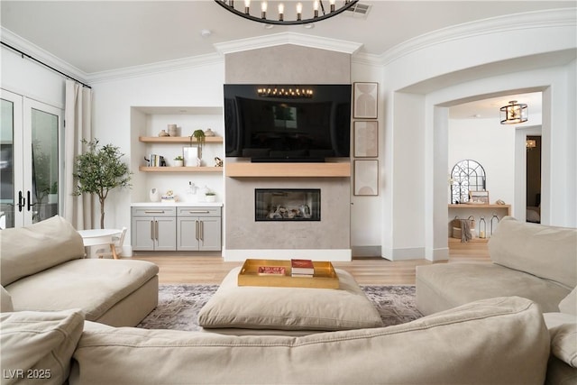 11830 Kingsbarns Ct, Las Vegas, NV 89141 - living room with a chandelier, light wood finished floors, a fireplace, and ornamental molding