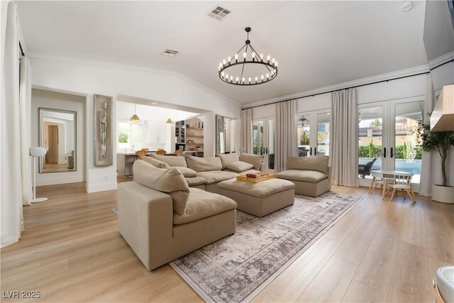 11830 Kingsbarns Ct, Las Vegas, NV 89141 - living area featuring vaulted ceiling, a chandelier, crown molding, light wood-style flooring, and french doors