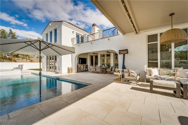 11830 Kingsbarns Ct, Las Vegas, NV 89141 - rear view of property with a balcony, stucco siding, an outdoor hangout area, a patio, and an outdoor pool