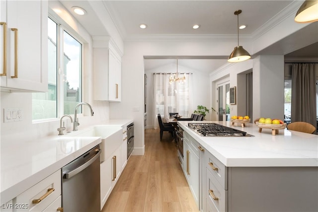 11830 Kingsbarns Ct, Las Vegas, NV 89141 - kitchen featuring appliances with stainless steel finishes, light wood-style floors, a center island, light countertops, and ornamental molding