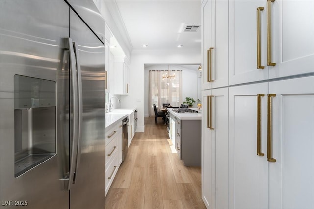 11830 Kingsbarns Ct, Las Vegas, NV 89141 - kitchen featuring stainless steel appliances, light countertops, a chandelier, white cabinetry, and light wood finished floors