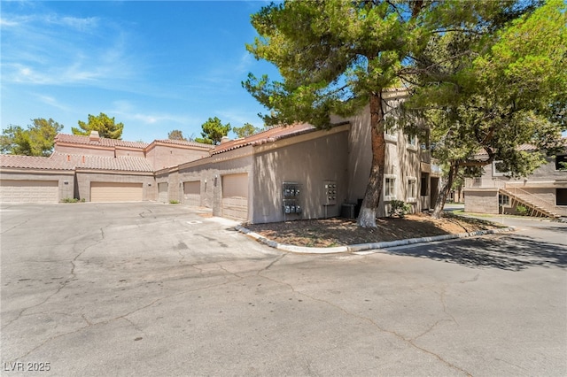 5250 S Rainbow Blvd Unit 1167, Las Vegas, NV 89118 - townhome / multi-family property featuring stucco siding, a tiled roof, and driveway