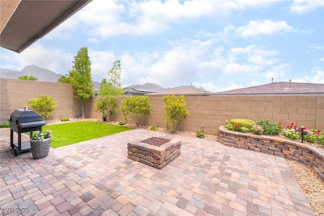 12478 Dolan Point St, Las Vegas, NV 89138 - fenced backyard featuring a grill, a patio, an outdoor fire pit, and a mountain view