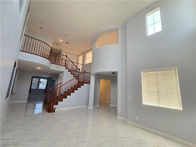 7428 Timber Run St, Las Vegas, NV 89149 - entryway featuring stairway, arched walkways, marble look tiles, a high ceiling, and healthy amount of natural light
