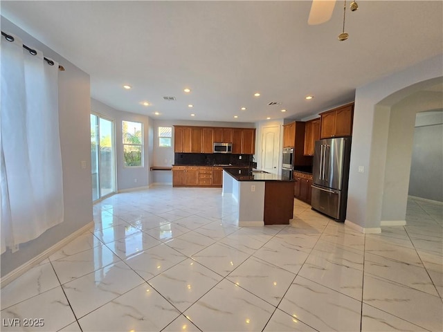 7428 Timber Run St, Las Vegas, NV 89149 - kitchen featuring stainless steel appliances, arched walkways, dark countertops, recessed lighting, and light marble finish flooring