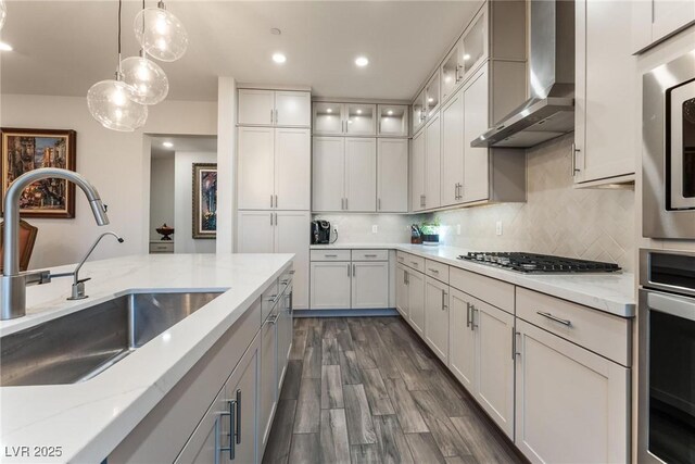 4122 Yucca Bloom St Unit 0, Las Vegas, NV 89135 - kitchen with wall chimney exhaust hood, stainless steel appliances, decorative light fixtures, light stone counters, and dark wood-style floors