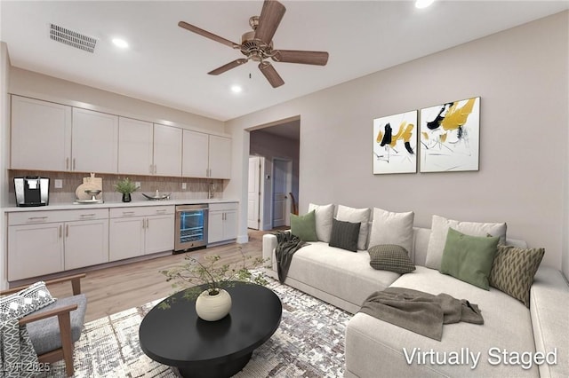 4122 Yucca Bloom St Unit 0, Las Vegas, NV 89135 - living room featuring beverage cooler, recessed lighting, light wood-style flooring, a ceiling fan, and bar area