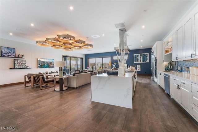 4122 Yucca Bloom St Unit 0, Las Vegas, NV 89135 - kitchen featuring a kitchen island, white cabinets, stainless steel appliances, dark wood finished floors, and tasteful backsplash