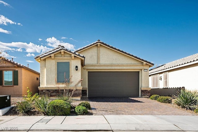 1110 Crystal Grotto Ave, North Las Vegas, NV 89081 - view of front facade featuring stucco siding, decorative driveway, stone siding, a garage, and a tiled roof