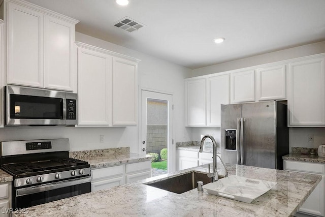 1110 Crystal Grotto Ave, North Las Vegas, NV 89081 - kitchen with appliances with stainless steel finishes, white cabinets, light stone counters, and recessed lighting