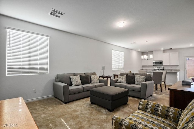 1110 Crystal Grotto Ave, North Las Vegas, NV 89081 - carpeted living room featuring a chandelier and baseboards