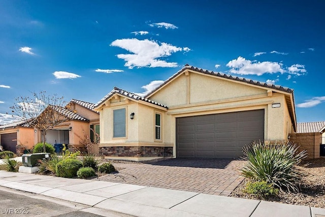 1110 Crystal Grotto Ave, North Las Vegas, NV 89081 - view of front of house featuring stucco siding, an attached garage, decorative driveway, stone siding, and a tile roof