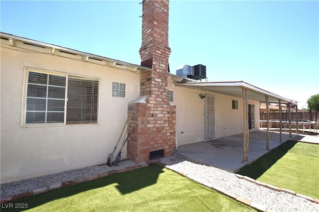 3323 Bancroft Cir, Las Vegas, NV 89121 - back of house with a patio area, stucco siding, a trampoline, and a chimney