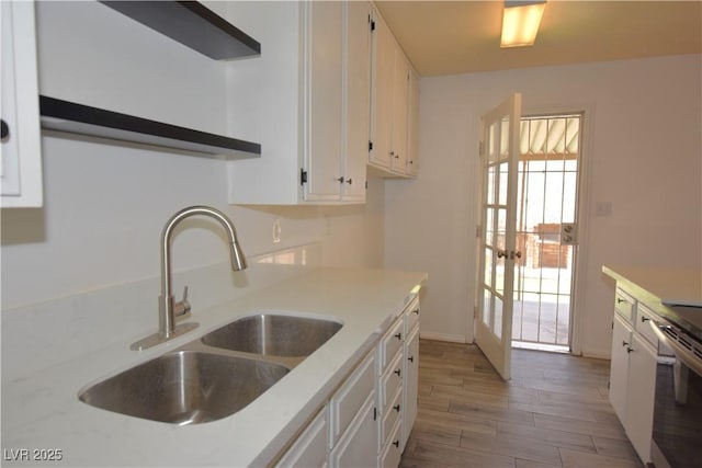 3323 Bancroft Cir, Las Vegas, NV 89121 - kitchen featuring white cabinetry, light wood-type flooring, light countertops, stainless steel electric range oven, and french doors
