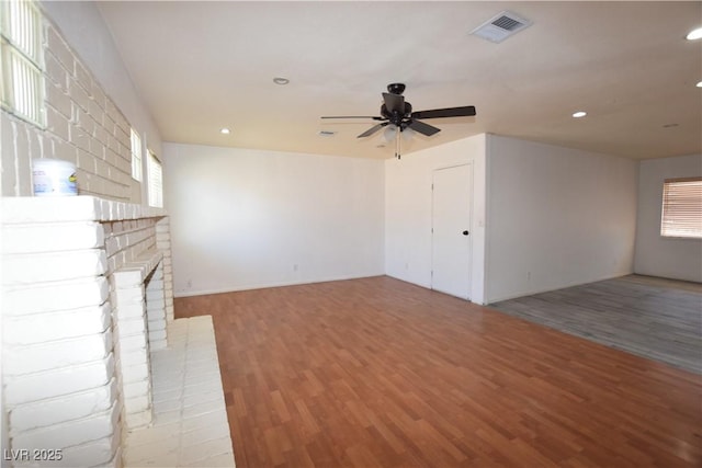 3323 Bancroft Cir, Las Vegas, NV 89121 - unfurnished living room with light wood-type flooring, ceiling fan, recessed lighting, and a brick fireplace