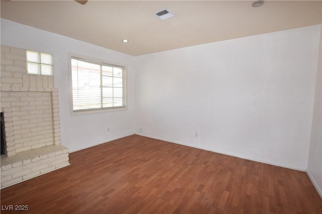 3323 Bancroft Cir, Las Vegas, NV 89121 - unfurnished living room featuring wood finished floors and a brick fireplace