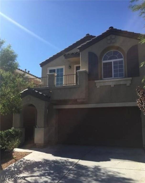 10225 Headrick Dr, Las Vegas, NV 89166 - mediterranean / spanish-style home featuring an attached garage, stucco siding, a balcony, and concrete driveway