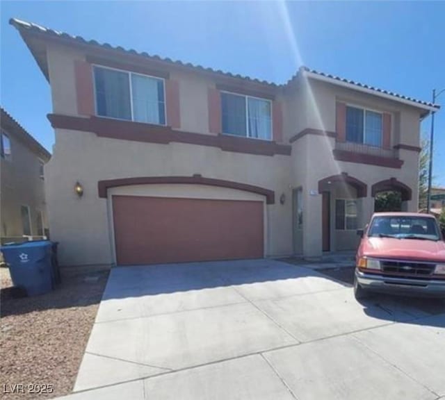 7349 Dolphine Crest Ave, Las Vegas, NV 89129 - mediterranean / spanish house featuring a garage, stucco siding, concrete driveway, and a tile roof