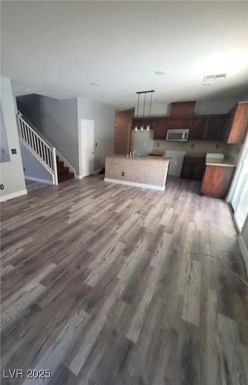 7349 Dolphine Crest Ave, Las Vegas, NV 89129 - unfurnished living room featuring wood finished floors and stairway