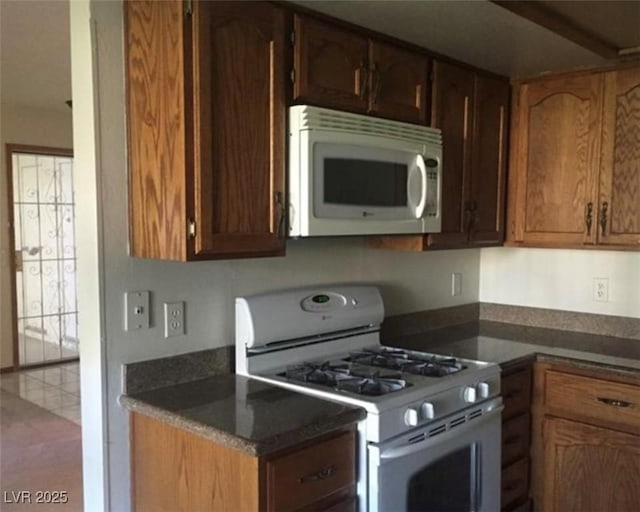 6671 W Tropicana Ave Unit 103, Las Vegas, NV 89103 - kitchen featuring white appliances and dark countertops