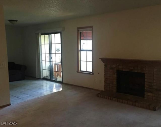6671 W Tropicana Ave Unit 103, Las Vegas, NV 89103 - unfurnished living room featuring a brick fireplace, carpet floors, and tile patterned flooring