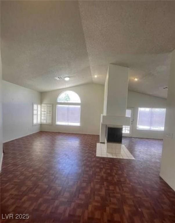 9820 Cross Creek Way, Las Vegas, NV 89117 - unfurnished living room featuring lofted ceiling, a fireplace, and a textured ceiling