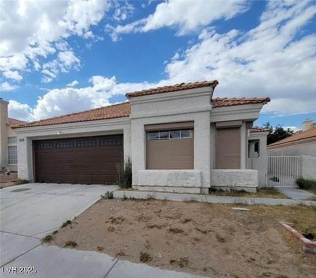 9820 Cross Creek Way, Las Vegas, NV 89117 - mediterranean / spanish home with a tiled roof, a garage, driveway, and stucco siding