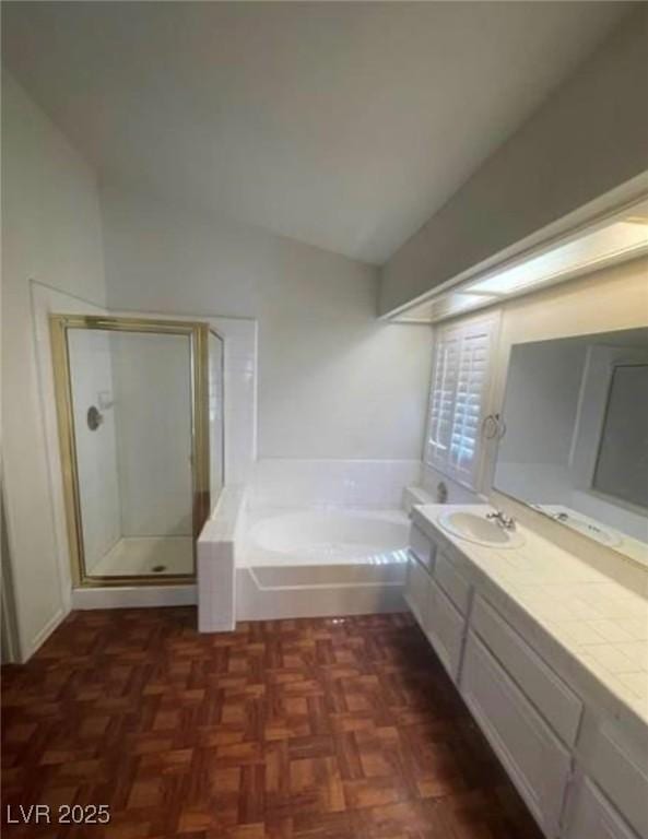 9820 Cross Creek Way, Las Vegas, NV 89117 - bathroom with vaulted ceiling, vanity, a garden tub, and a stall shower