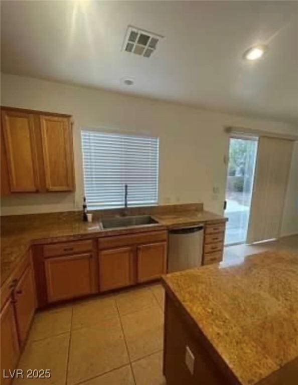 7879 Villa Pintura Ave, Las Vegas, NV 89131 - kitchen featuring stainless steel dishwasher, light tile patterned flooring, recessed lighting, brown cabinets, and light stone counters