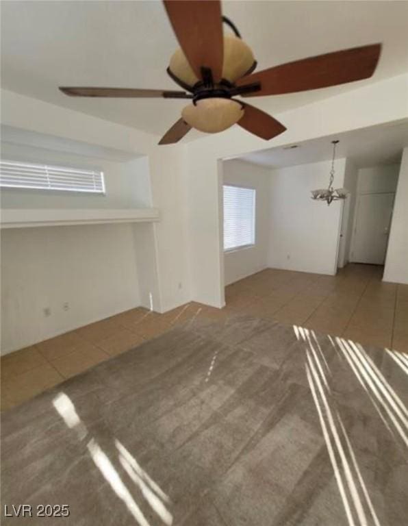 7879 Villa Pintura Ave, Las Vegas, NV 89131 - unfurnished living room with tile patterned floors, a ceiling fan, carpet flooring, and a chandelier