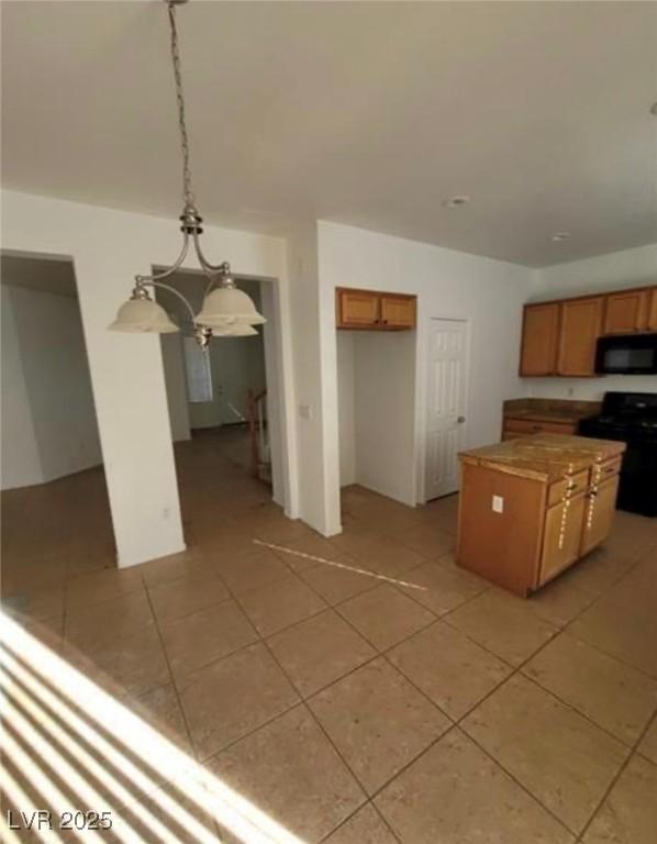 7879 Villa Pintura Ave, Las Vegas, NV 89131 - kitchen featuring black appliances, light tile patterned floors, brown cabinetry, and a center island