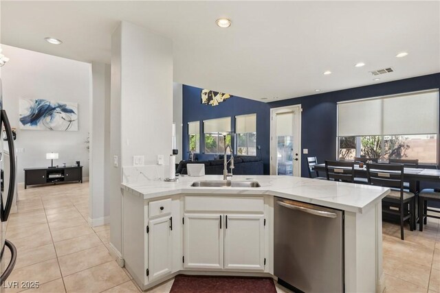 217 Turkey Creek Way, Henderson, NV 89074 - kitchen with stainless steel dishwasher, light stone counters, light tile patterned floors, white cabinetry, and recessed lighting