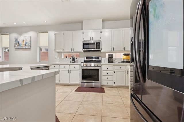 217 Turkey Creek Way, Henderson, NV 89074 - kitchen featuring stainless steel appliances, light stone countertops, light tile patterned flooring, recessed lighting, and white cabinets