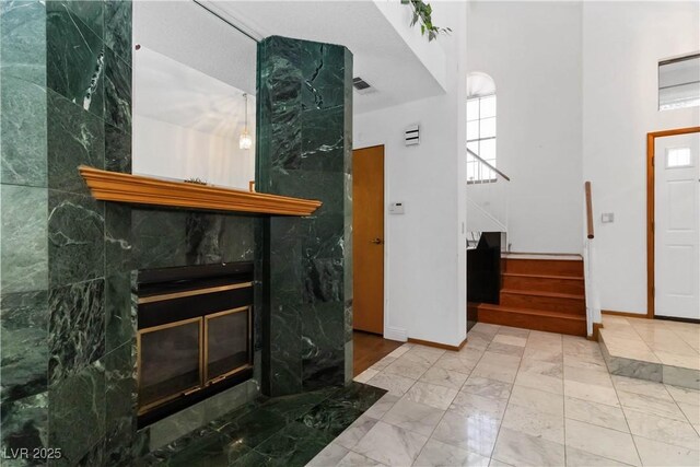 9109 Anchor Cove Ct, Las Vegas, NV 89117 - entrance foyer with stairway, a towering ceiling, a premium fireplace, and marble look tile flooring