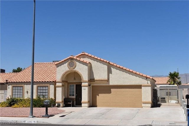 5105 Wildroot Rd, Las Vegas, NV 89130 - mediterranean / spanish house with a tile roof, an attached garage, stucco siding, driveway, and a gate