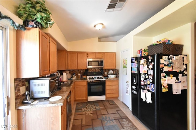 5105 Wildroot Rd, Las Vegas, NV 89130 - kitchen with stainless steel appliances, tasteful backsplash, light countertops, vaulted ceiling, and light brown cabinets