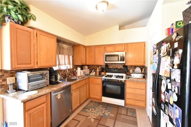 5105 Wildroot Rd, Las Vegas, NV 89130 - kitchen with stainless steel appliances, vaulted ceiling, backsplash, light countertops, and light brown cabinets