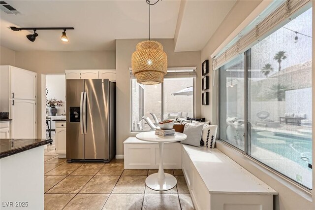 2535 Cortina Ave, Henderson, NV 89074 - kitchen featuring stainless steel fridge with ice dispenser, white cabinetry, light tile patterned floors, rail lighting, and decorative light fixtures