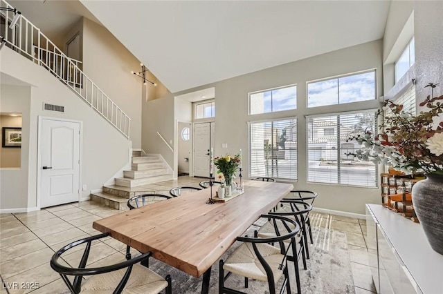 2535 Cortina Ave, Henderson, NV 89074 - dining room featuring a towering ceiling, healthy amount of natural light, stairway, and light tile patterned floors