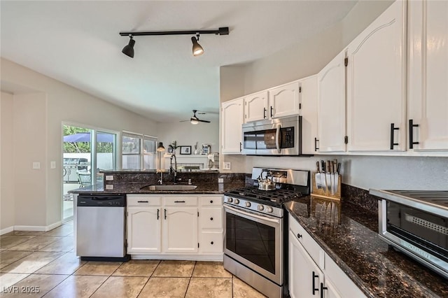 2535 Cortina Ave, Henderson, NV 89074 - kitchen with appliances with stainless steel finishes, a peninsula, white cabinets, and dark stone counters