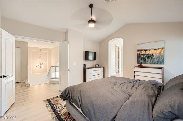 2535 Cortina Ave, Henderson, NV 89074 - bedroom featuring light wood-type flooring, vaulted ceiling, arched walkways, a chandelier, and ceiling fan